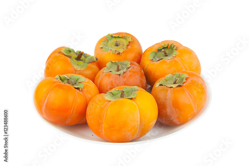 tasty ripe persimmon isolated on plate on  white
