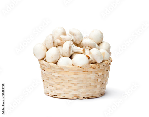 heap of fresh mushroom champignons in a basket isolated on whit