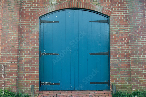 Vintage blue gate and red brick wall in old windmill
