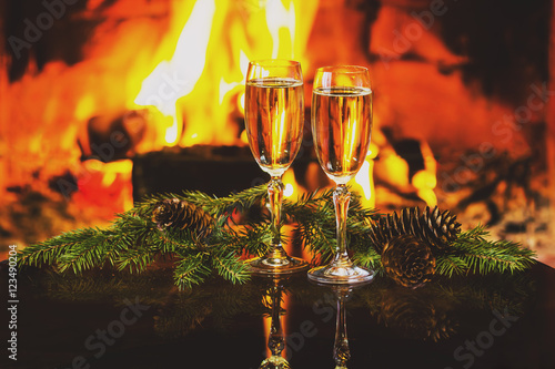 Two glasses of wine and Christmas New Year decoration, fireplace