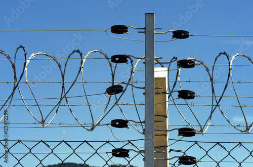 Detail of electric fence with concertina wire photo