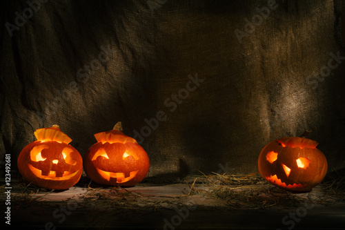 Halloween pumpkin head jack lantern on burlap background