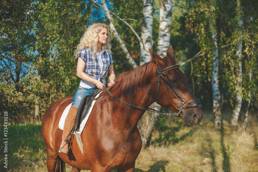 Portrait of young beautiful woman riding horse
