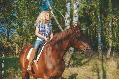 Portrait of young beautiful woman riding horse