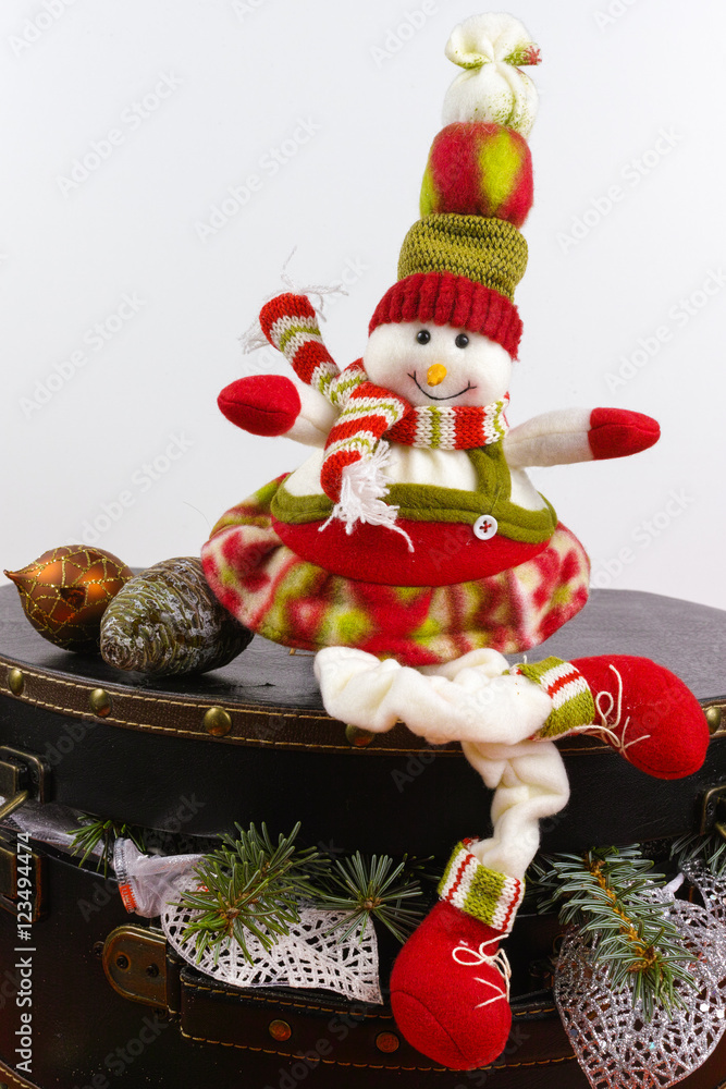 Funny snowman sits on vintage brown coffer with white christmas