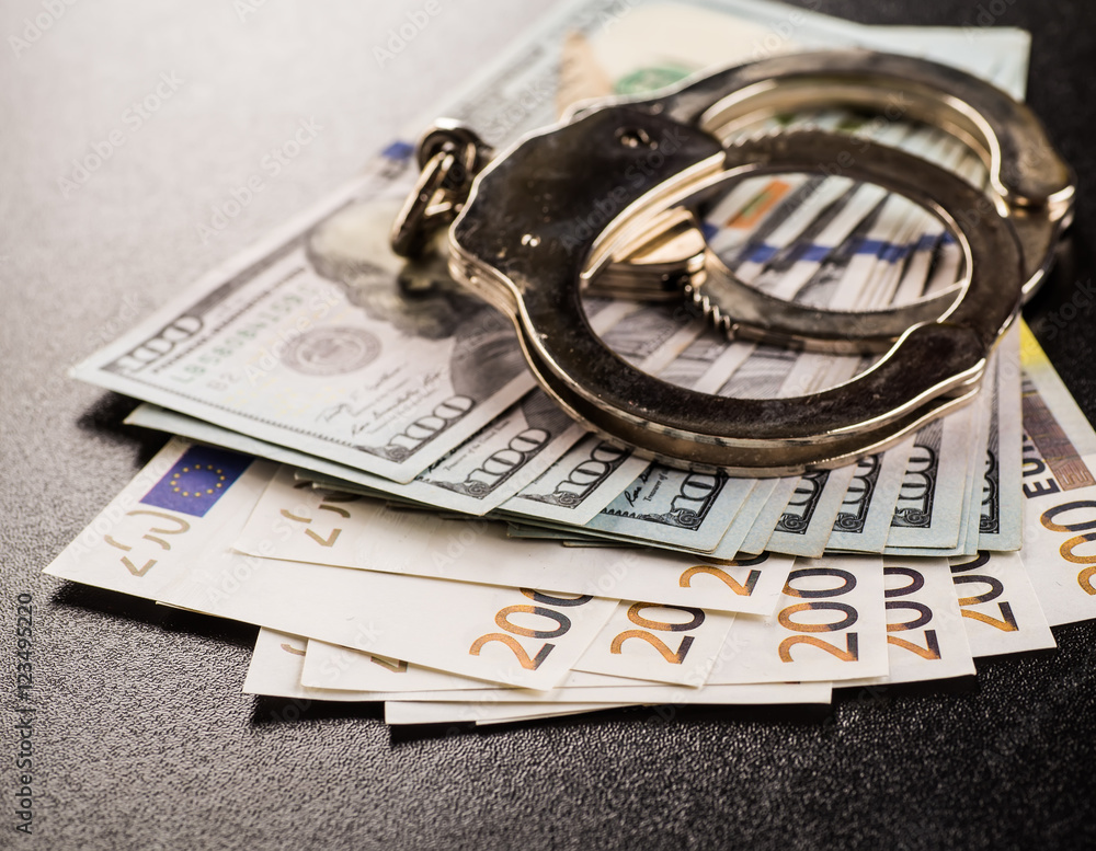 Handcuffs and money on the table Handcuffs and money on the table