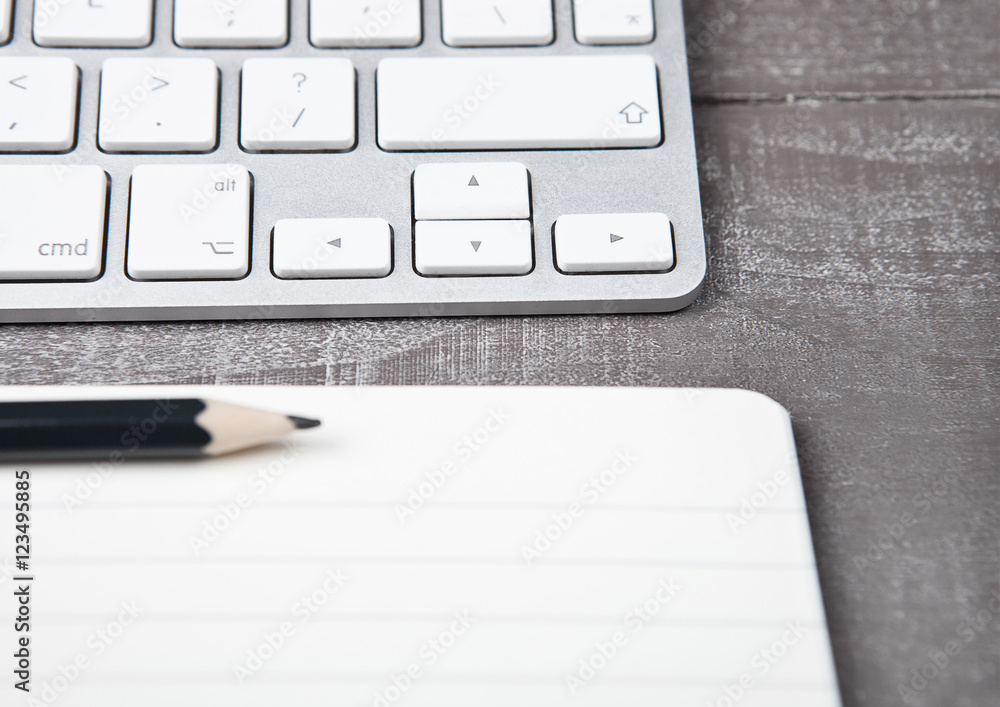 Keyboard with pencil on open notebook sheet Keyboard with pencil on open notebook sheet