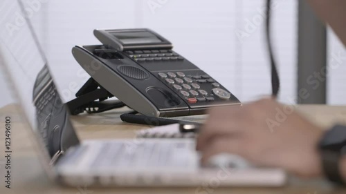 Male hands typing and answering a phone
