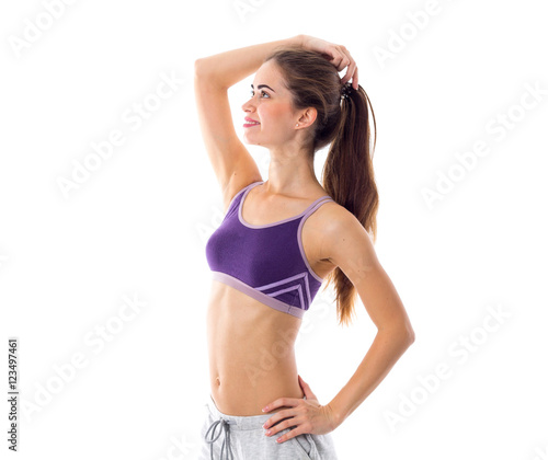 Athletic woman in sportswear standing sidewise