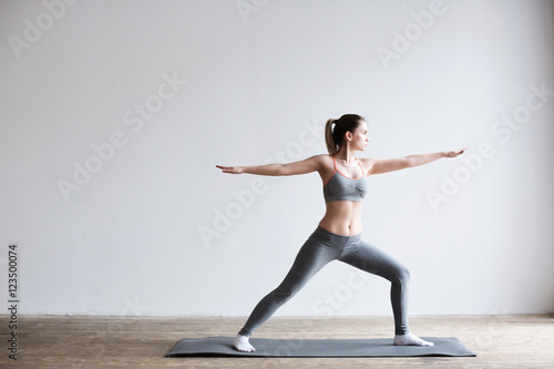 Fototapeta Naklejka Na Ścianę i Meble -  Woman doing yoga indoors on yoga mat.
