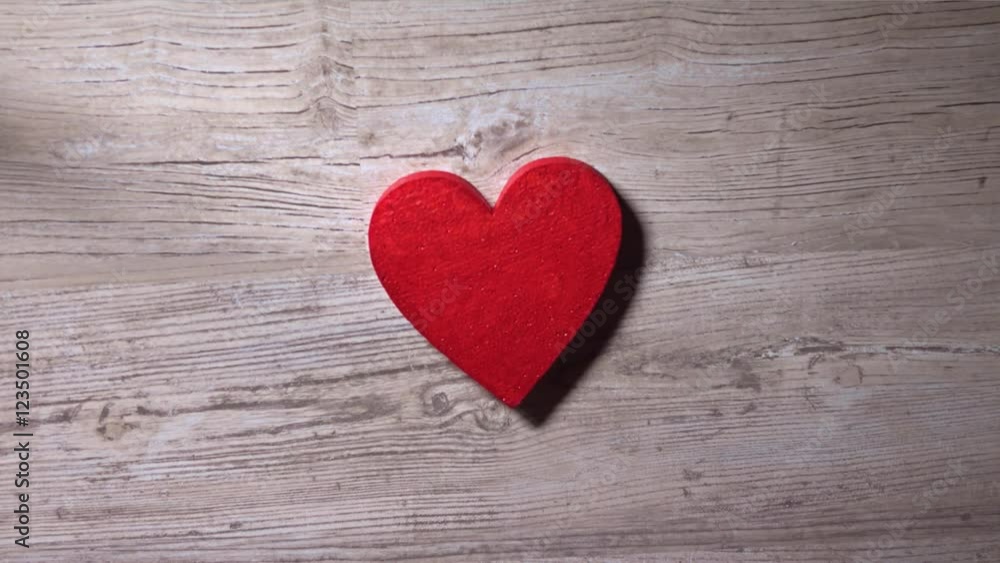 Girl placing red heart on a wooden table, top view. Romance, love, Valentine's day, solitude concepts. 4K video Girl placing red heart on a wooden table, top view. Romance, love, Valentine's day, solitude concepts. 4K video
