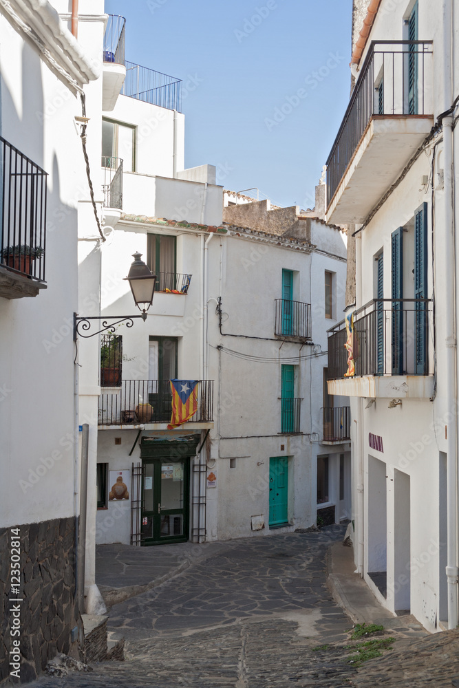 narrow street with white houses in historical center of Cadaques, spain