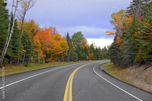 Driving into the mountains with Autumn foliage with red, orange and yellow fall colors in A Northeast forest
