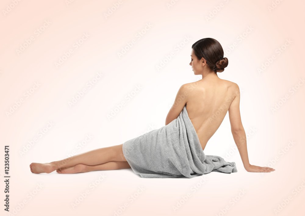Fototapeta premium Young beautiful woman with towel on light background