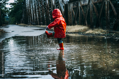Fototapeta .Boy splashing in puddle
