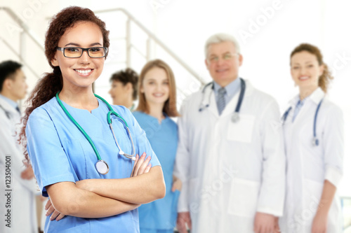 Young doctor and medical team on blurred hospital background. Health care concept.