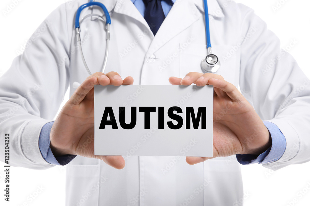 Children autism concept. Male doctor holding paper on white background, closeup Children autism concept. Male doctor holding paper on white background, closeup