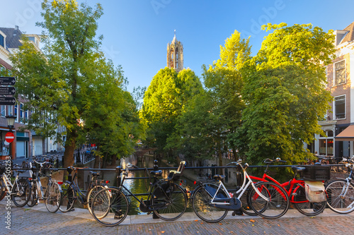 Dom Tower, canal and bridge with bikes in the sunny evening, Utrecht, Netherlands