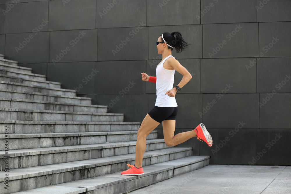 Fototapeta premium young sport woman running upstairs on city stairs
