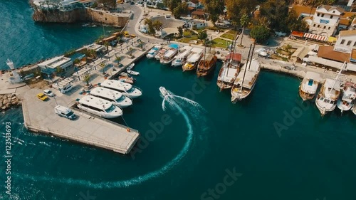 Aerial View of Swimming and Parking Boat in an Old Port, Tourists Walk Around. Sunny Day, Shot in 4K UHD photo