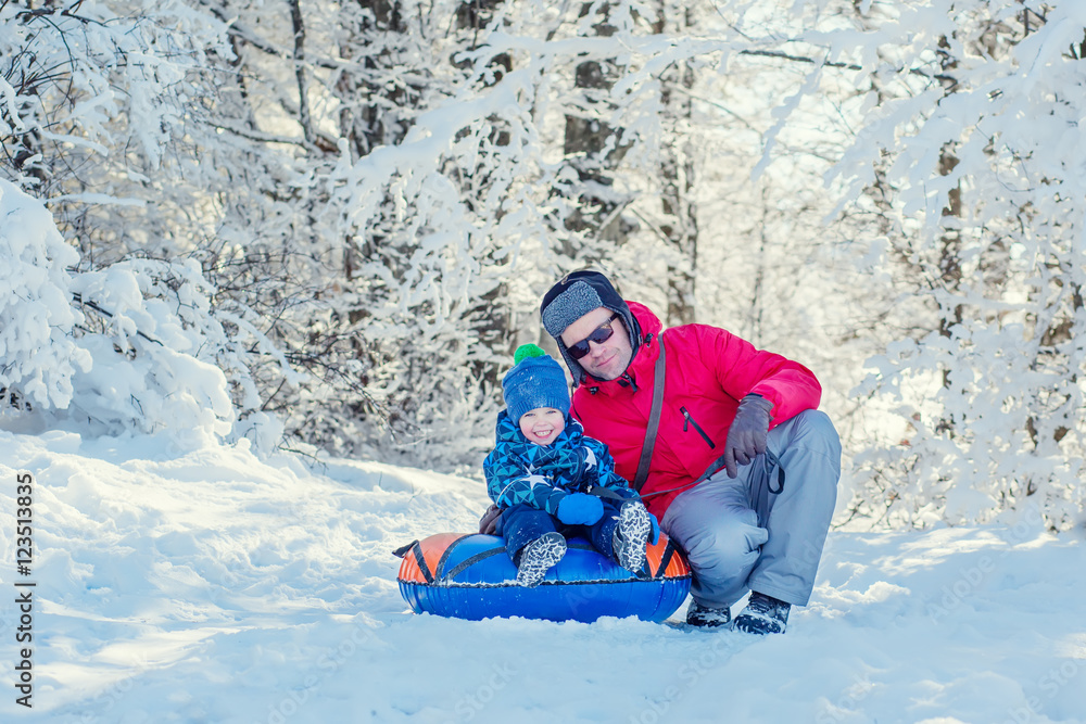 Happy Toddler boy with dad in the snowy forest