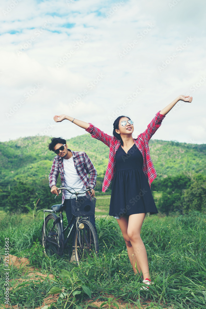 Young hipster couple holding hands walking on the meadow relaxin Young hipster couple holding hands walking on the meadow relaxin