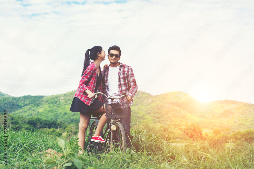 Young hipster couple holding hands walking on the meadow relaxin Young hipster couple holding hands walking on the meadow relaxin