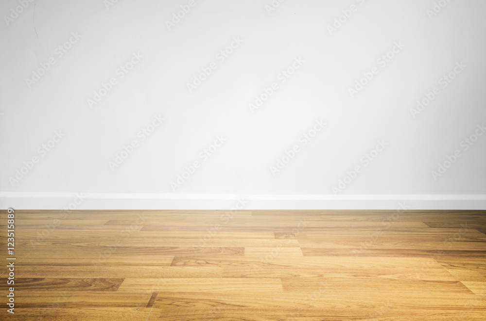 Laminated wood floor with white wall - obrazy, fototapety, plakaty 