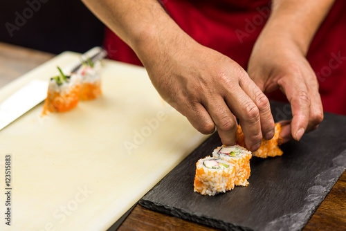 Chef preparing sushi rolls.