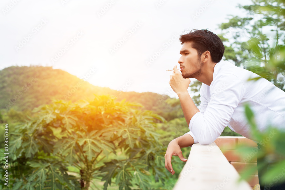 Young hipster man taking rest, smoking cigarette with nature and Young hipster man taking rest, smoking cigarette with nature and