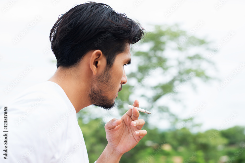 Young hipster man taking rest, smoking cigarette with nature and Young hipster man taking rest, smoking cigarette with nature and