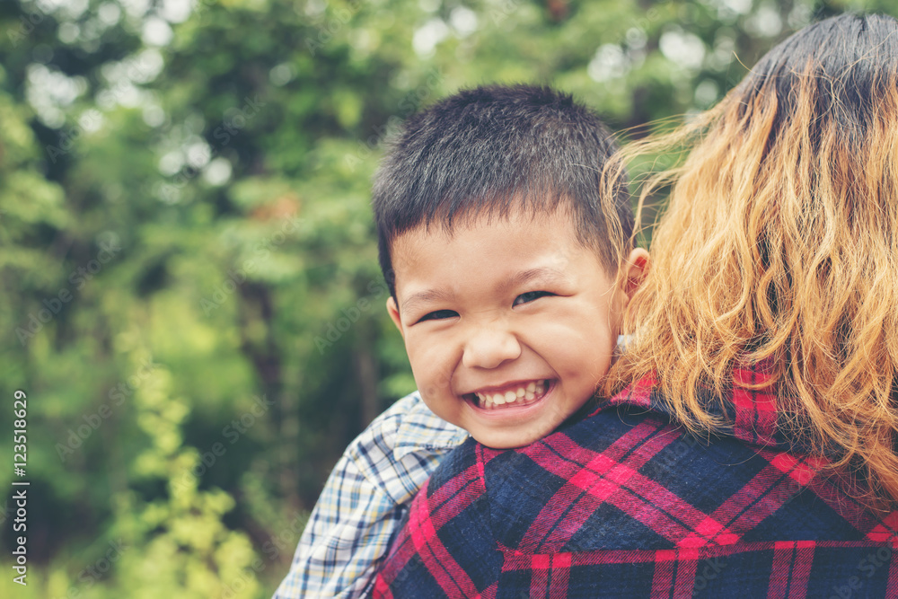 Little cute asian boy hug with her mom and smiling to camera hap Little cute asian boy hug with her mom and smiling to camera hap