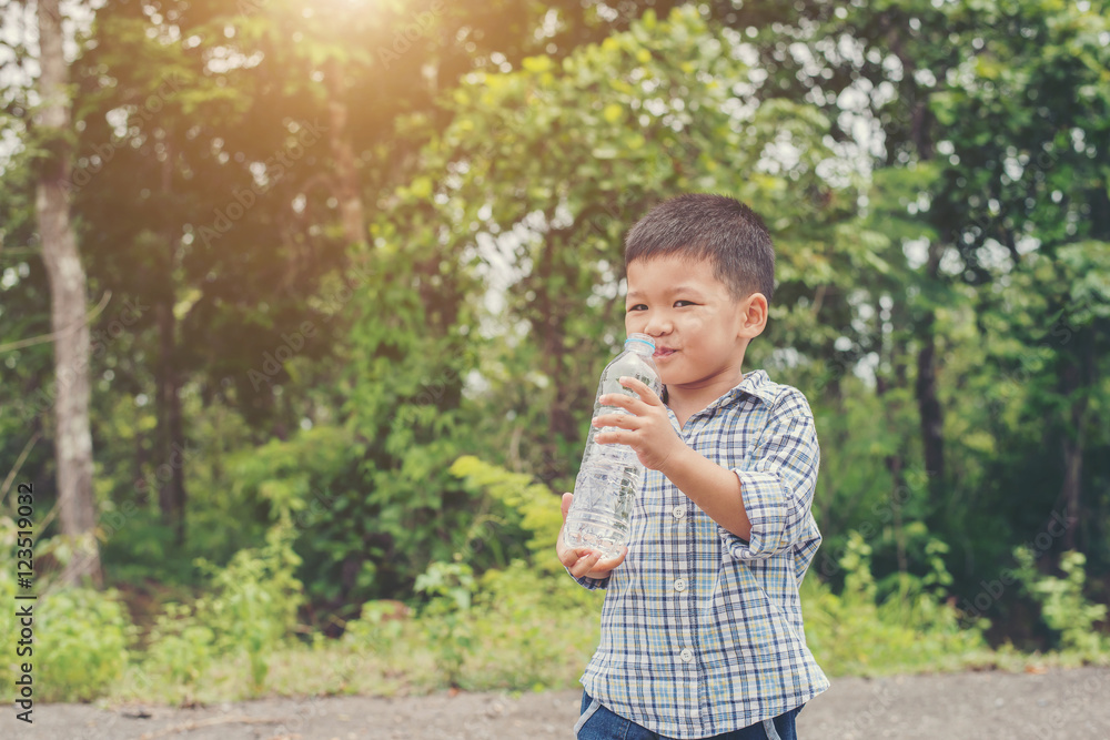 Little cute asian boy drink water on the roadside. Little cute asian boy drink water on the roadside.