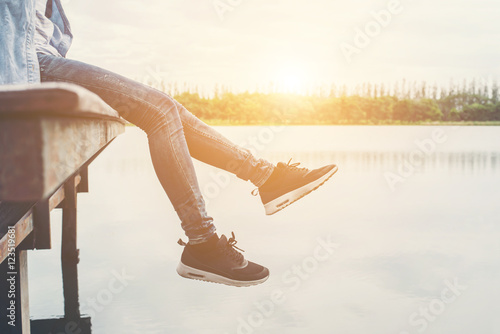 Hipster women feets laying on the lake relaxing with her holiday