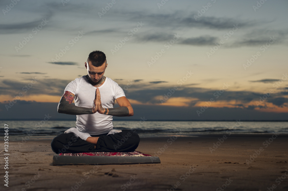 Fototapeta premium Yoga practice outdoors: man sitting in lotus pose