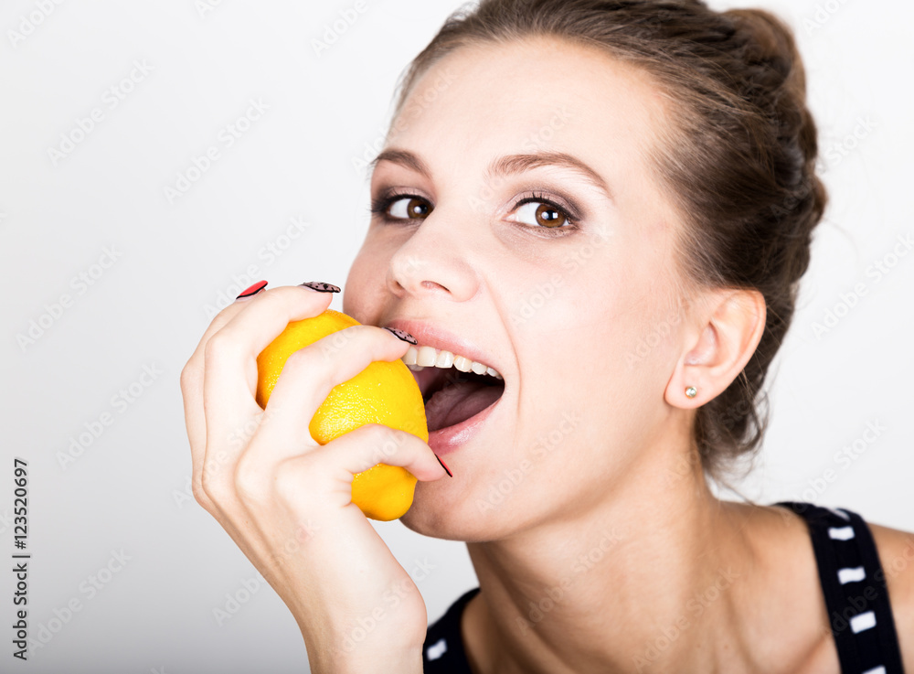 Happy smiling young woman holding fresh juicy lemons. Healthy eating, fruits and vegetables. Happy smiling young woman holding fresh juicy lemons. Healthy eating, fruits and vegetables.