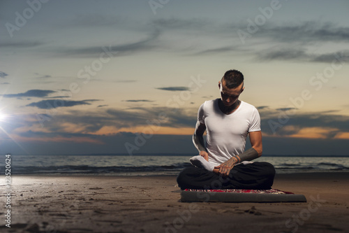 Flexible young man in lotus yoga pose