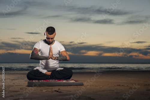 Yoga practice outdoors: man sitting in lotus pose