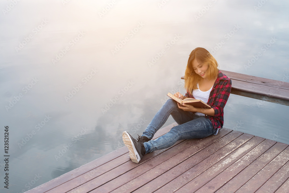 young beautiful hipster woman relaxing sitting on pier reading b young beautiful hipster woman relaxing sitting on pier reading b