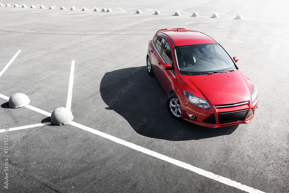 Obraz premium Red car stay on asphalt parking lot at daytime