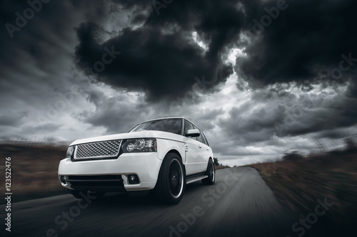White car speed driving on road at dramatic clouds daytime © Ivan Kurmyshov