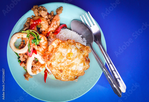 Rice topped with stir-fried pork and seafood, basil and fried egg, fried rice with basil photo