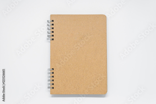 Brown plain notebook with ring on white background and selective focus