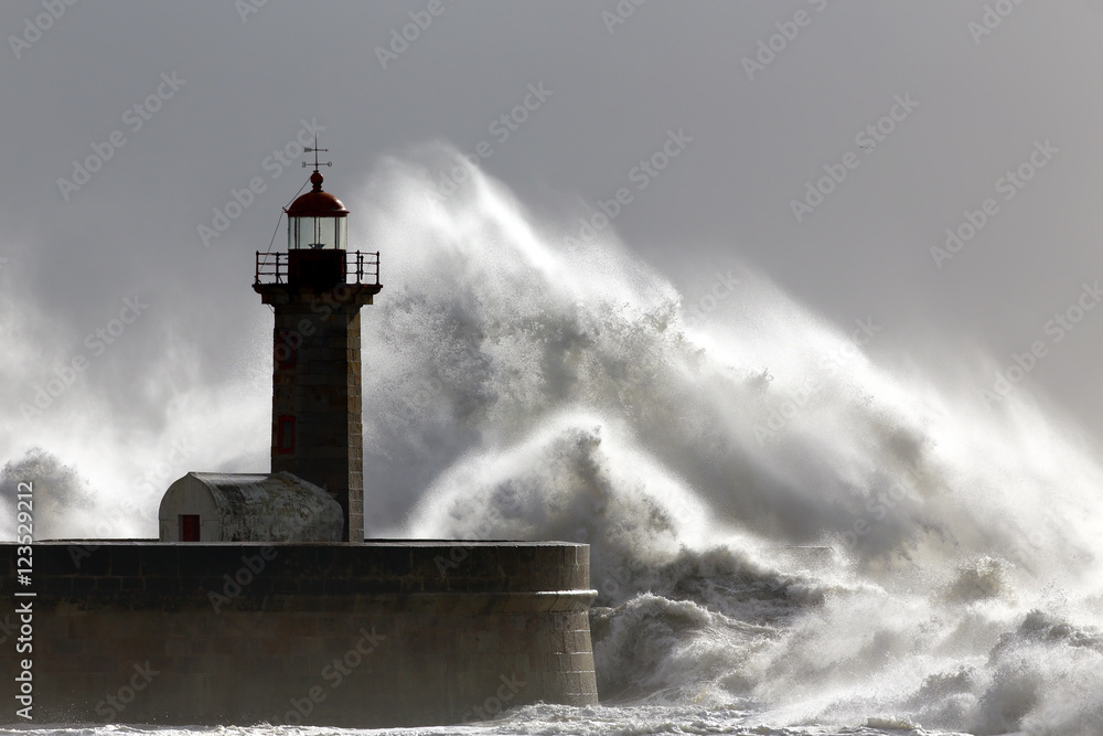Big stormy waves over old lighthouse