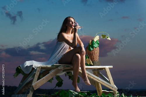 pretty woman with wine over sky photo