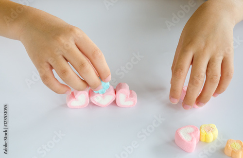 Child hands play jellys on white table