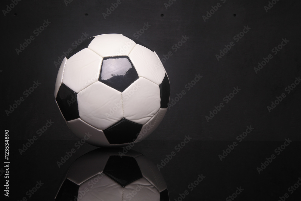 black white soccer ball on black background