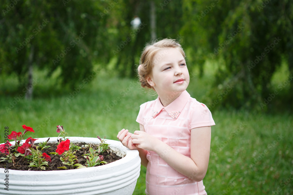 Portrait of beautiful little girl in a Park near the flower beds Portrait of beautiful little girl in a Park near the flower beds