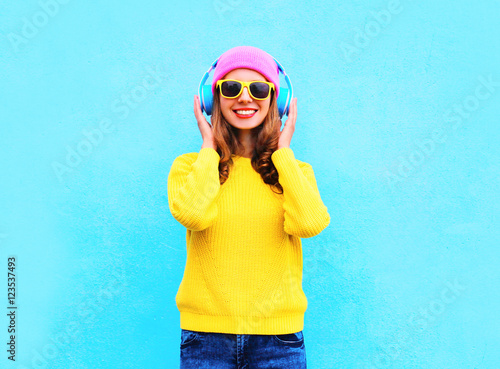Fashion pretty cool smiling girl listening to music in headphone