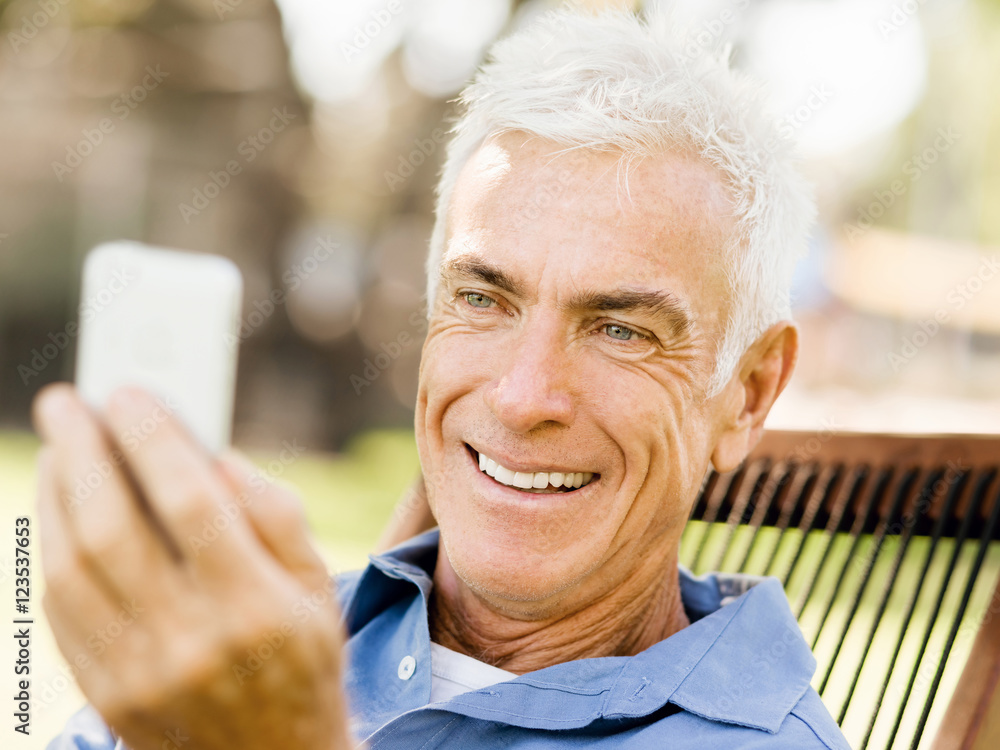 LoMature man outdoors using mobile phone LoMature man outdoors using mobile phone